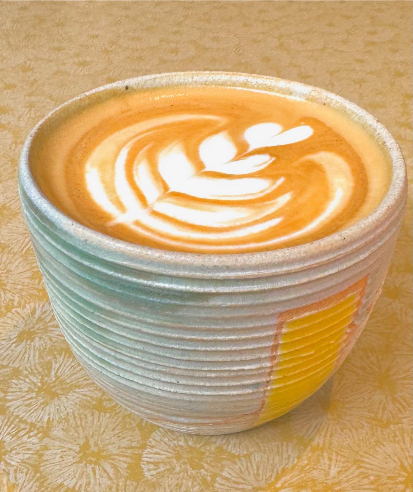 Flat white with latte art in a handmade ceramic mug at Wired Whippet Coffee